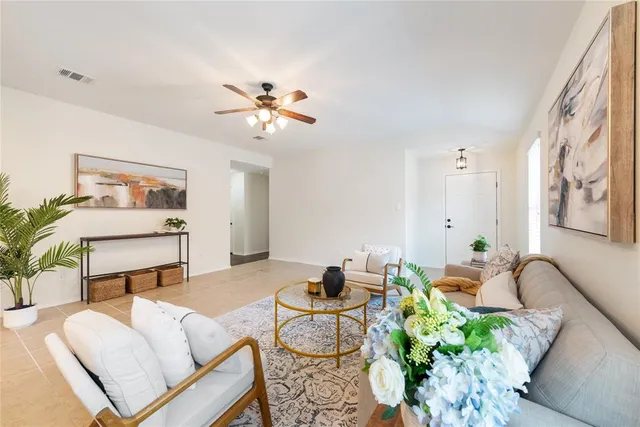 a living room with furniture flowerpot and a chandelier
