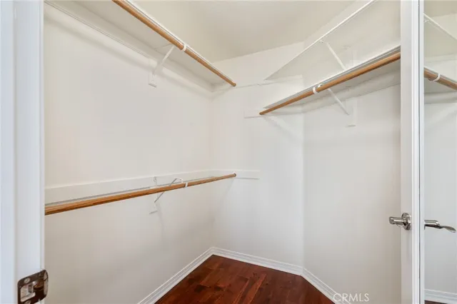 a view of a hallway with wooden floor and closet