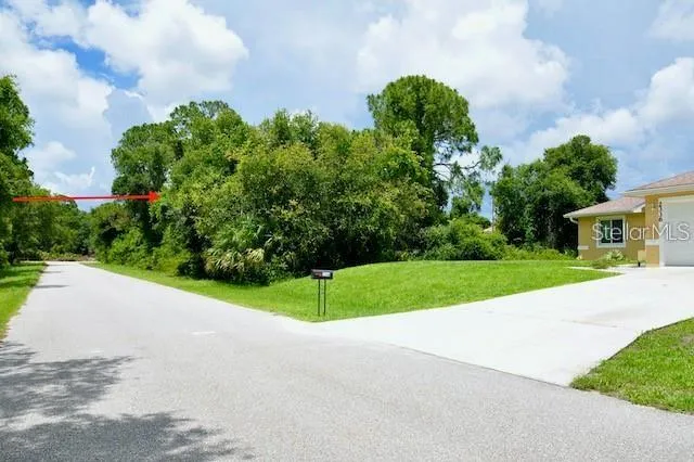 a view of a house with a big yard and large trees