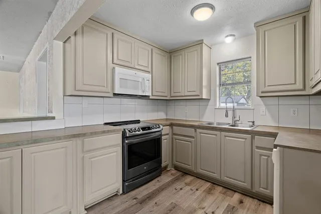 a kitchen with granite countertop cabinets stainless steel appliances and a sink