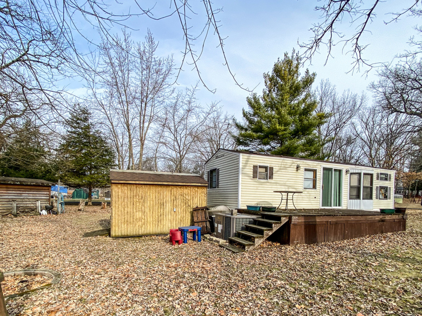 2-110 Woodhaven Lakes Sublette, IL 61367 - Photo 2 of 16 a view of a blue house with a yard and sitting area