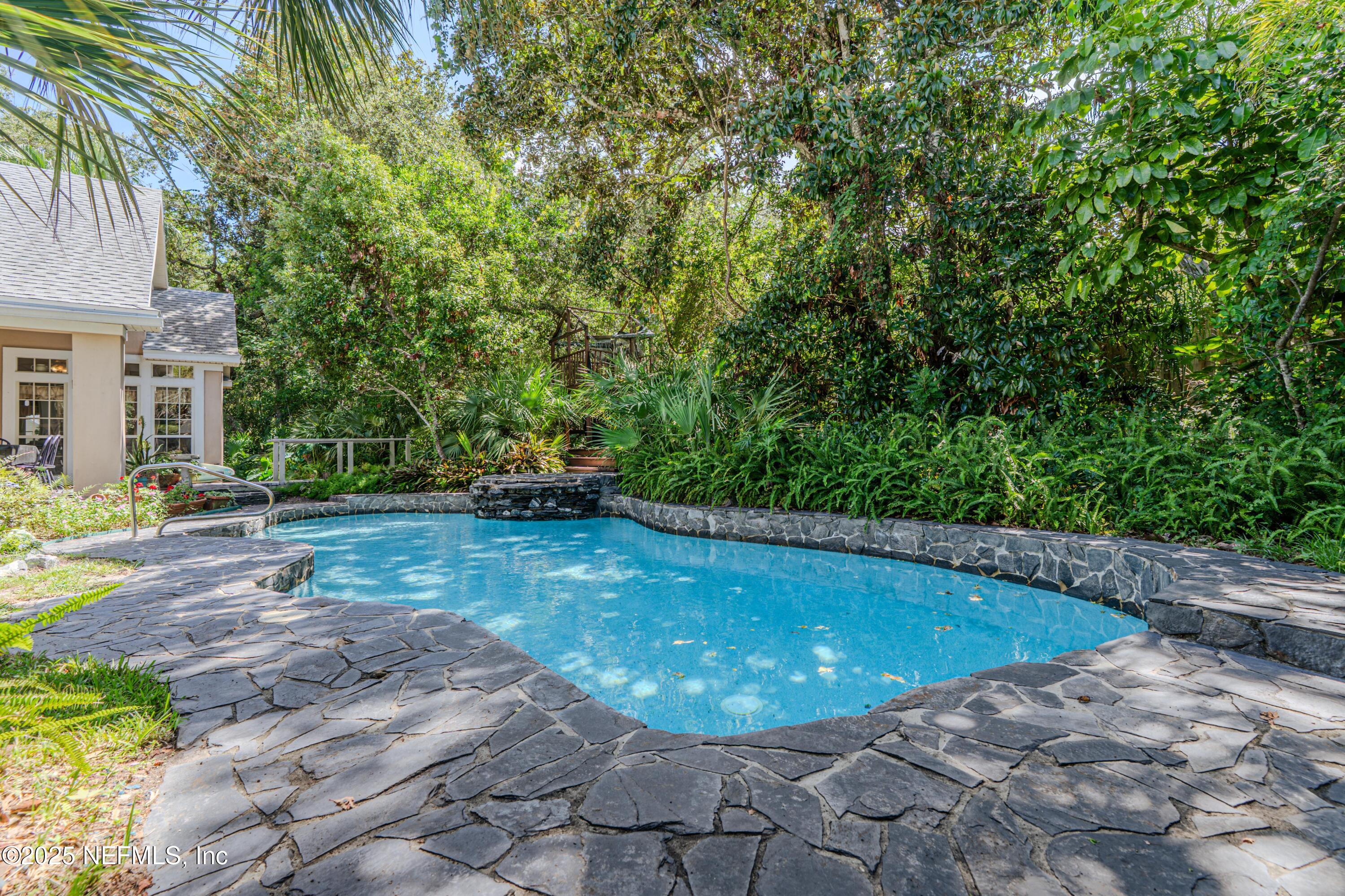 244 Bluebird Lane St. Augustine Beach, FL 32080 - Photo 51 of 66 a view of a swimming pool with lawn chairs under an umbrella