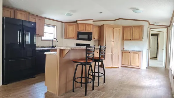 a kitchen with stainless steel appliances granite countertop a refrigerator and microwave