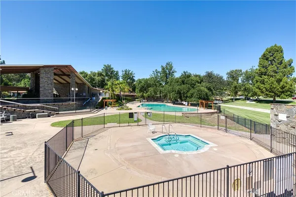 a view of a swimming pool with a patio and a yard