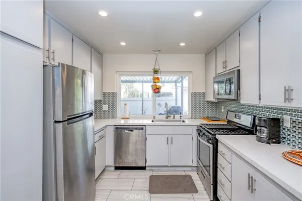 a kitchen with a sink a refrigerator and cabinets