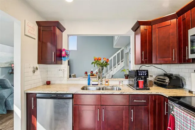 a kitchen with stainless steel appliances granite countertop a sink stove and cabinets