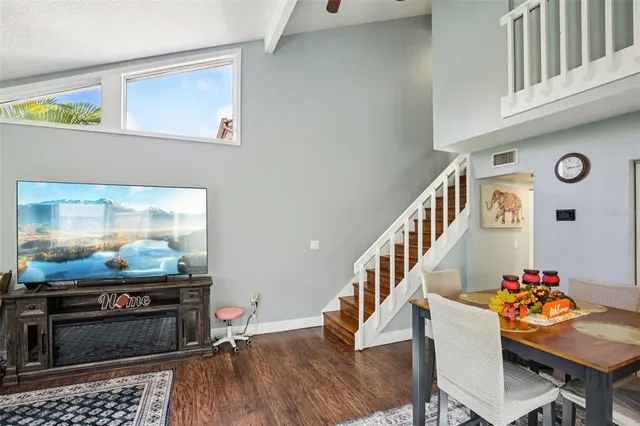 a dining room with wooden floor and stairs