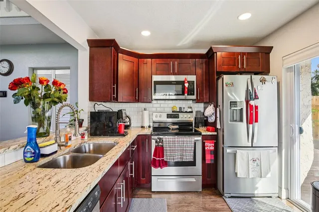 a kitchen with stainless steel appliances granite countertop a refrigerator sink and microwave