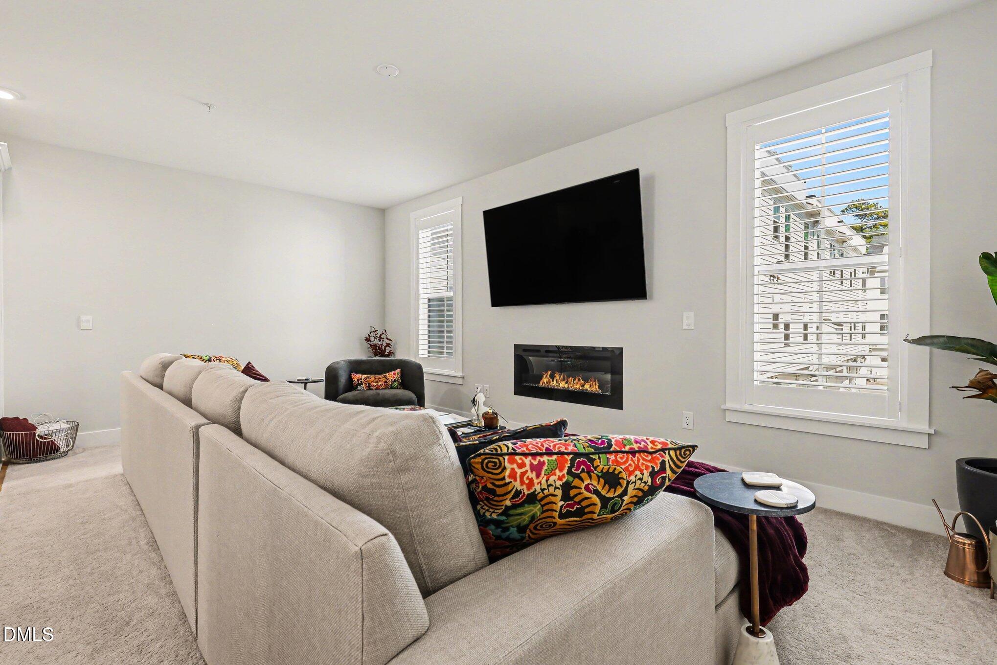 11549 Helmond Way, Unit 115 Raleigh, NC 27617 - Photo 5 of 25 a living room with furniture a flat screen tv and a fireplace