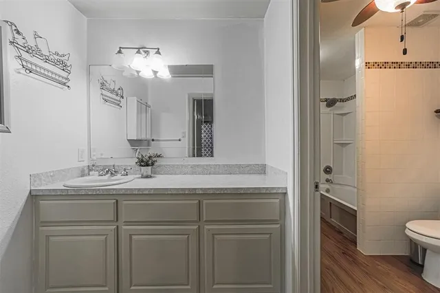 a bathroom with a granite countertop sink a toilet and a mirror