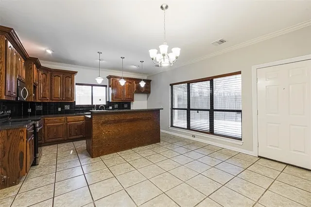 a large kitchen with stainless steel appliances granite countertop a refrigerator a oven and a sink with granite countertops