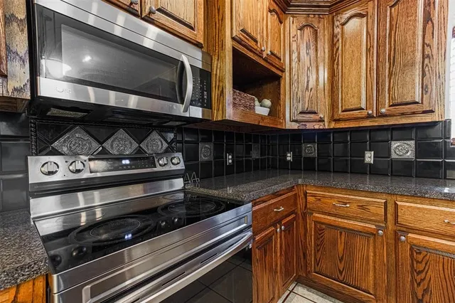 a kitchen with stainless steel appliances granite countertop a stove and a microwave