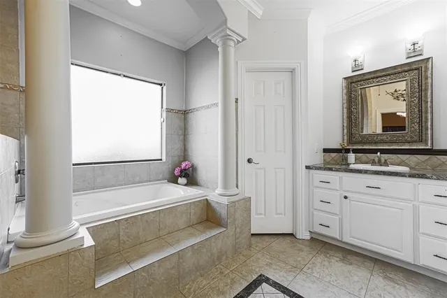 a bathroom with a tub a sink and a window