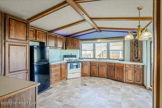 a kitchen with stainless steel appliances granite countertop a refrigerator and wooden cabinets