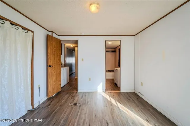 a view of hallway with wooden floor and closet