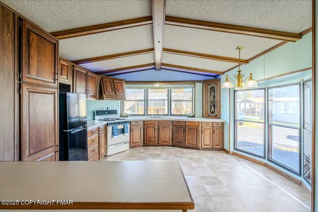 a kitchen with stainless steel appliances granite countertop a refrigerator and a stove top oven