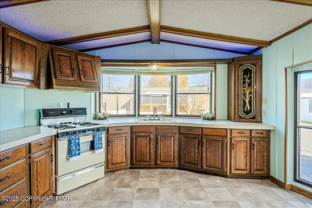 a kitchen with stainless steel appliances granite countertop a stove sink and cabinets