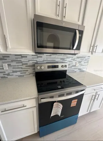 a stove top oven sitting inside of a kitchen