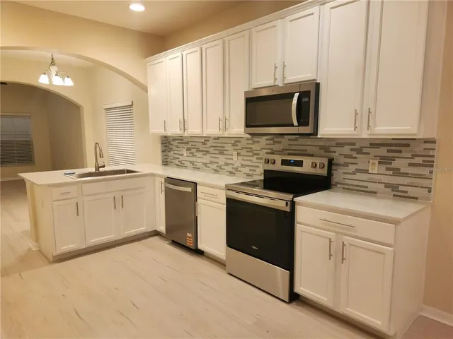 a kitchen with white cabinets and white appliances