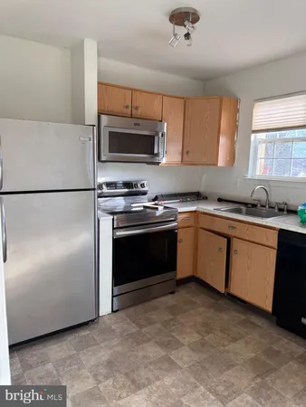 a kitchen with granite countertop stainless steel appliances and white cabinets