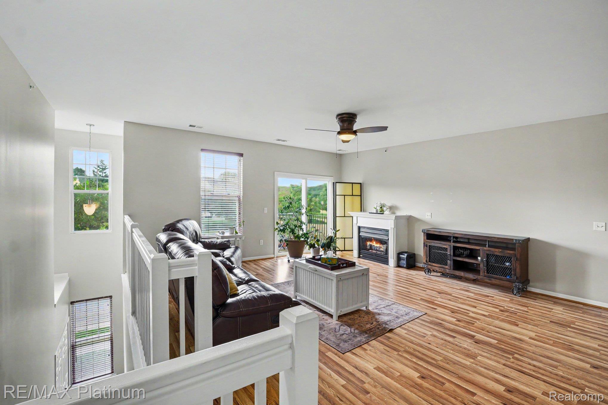 10217 Crossview Trail Howell, MI 48855 - Photo 18 of 26 Spacious living area featuring wood-finish flooring, a ceiling fan, and multiple windows
