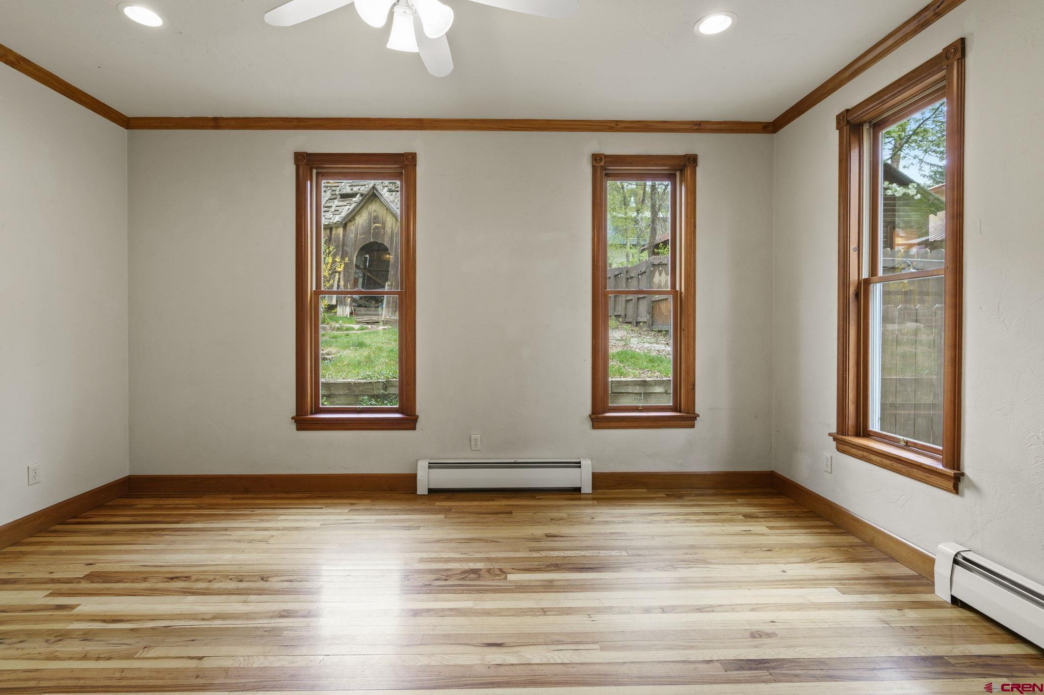 1330 East 3rd Avenue Durango, CO 81301 - Photo 22 of 32 a view of an empty room with window a ceiling fan and wooden floor