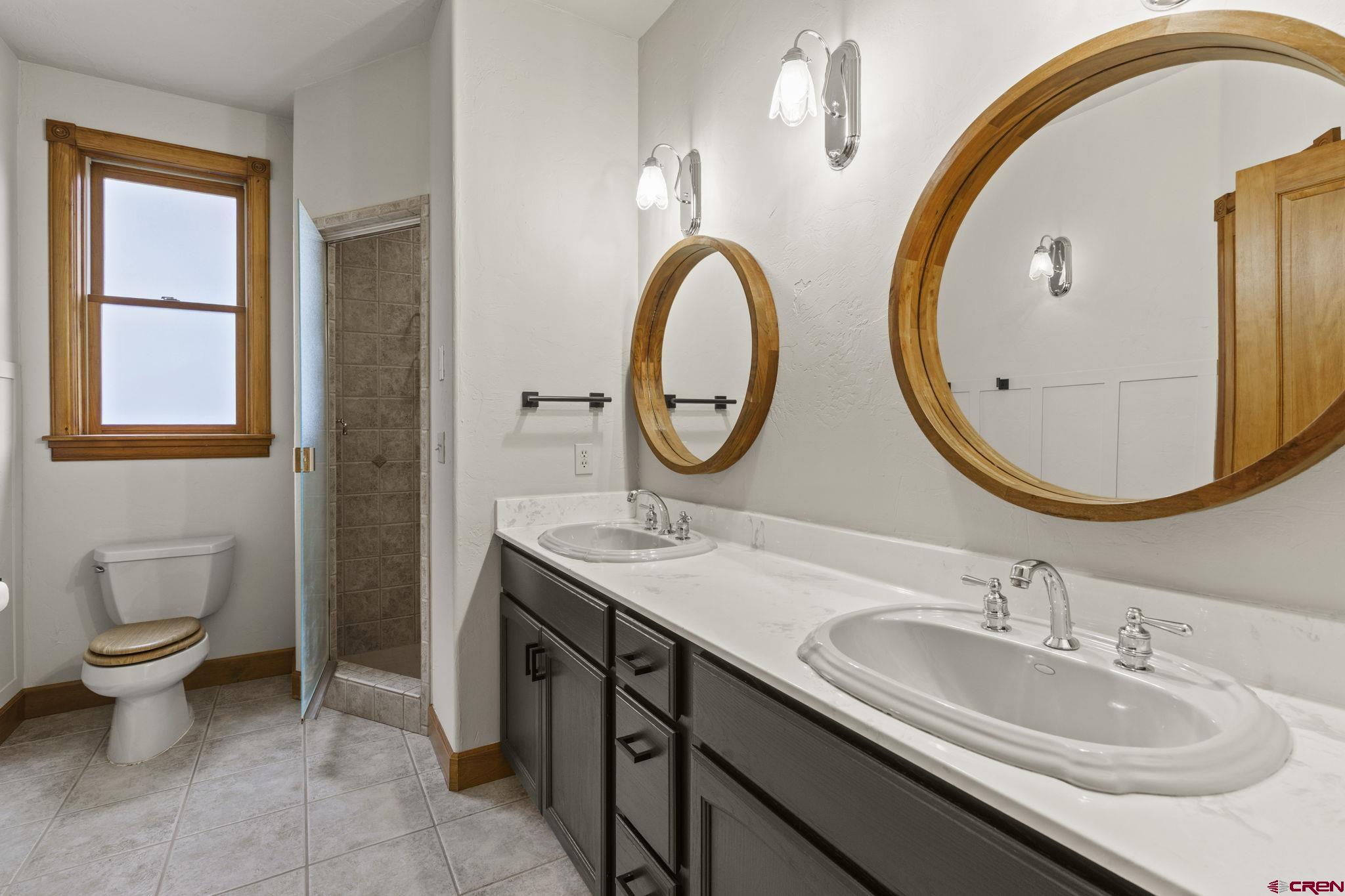 1330 East 3rd Avenue Durango, CO 81301 - Photo 24 of 32 a bathroom with a granite countertop toilet a sink and a mirror