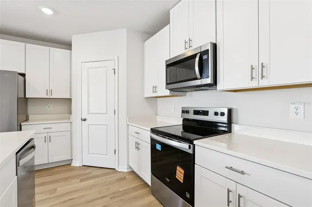 a kitchen with white cabinets and stainless steel appliances