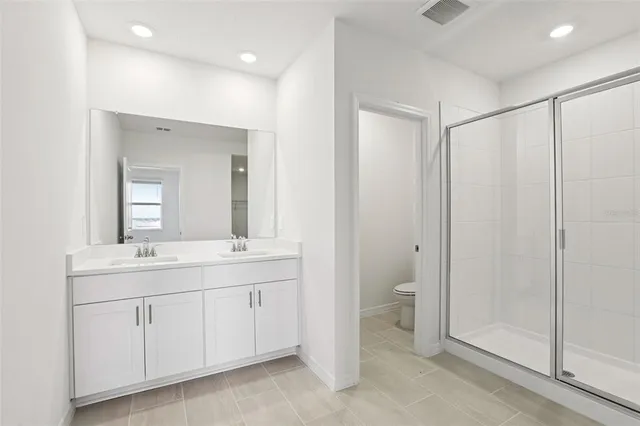 a bathroom with a double vanity sink and a toilet