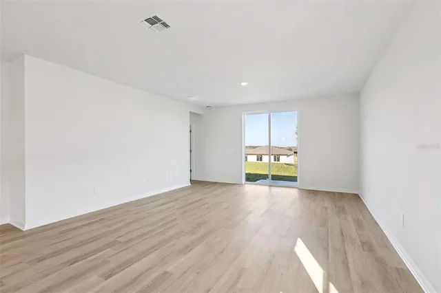 a view of a room with wooden floor and a window