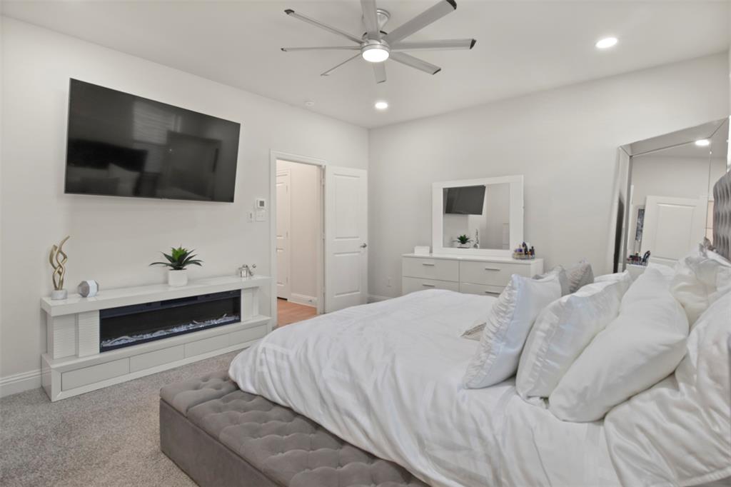 4125 Fern Loop Forney, TX 75126 - Photo 14 of 40 Recessed lighting, ceiling fan, white walls, and built-in electric fireplace