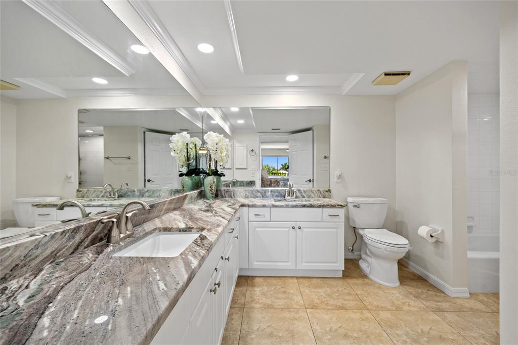 601 Shreve Street, Unit 53C Punta Gorda, FL 33950 - Photo 14 of 30 a large bathroom with a granite countertop sink a toilet a mirror and bathtub