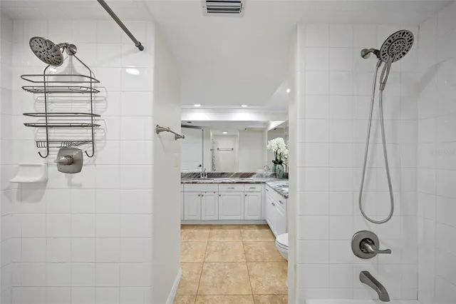 a bathroom with a granite countertop sink a toilet and shower