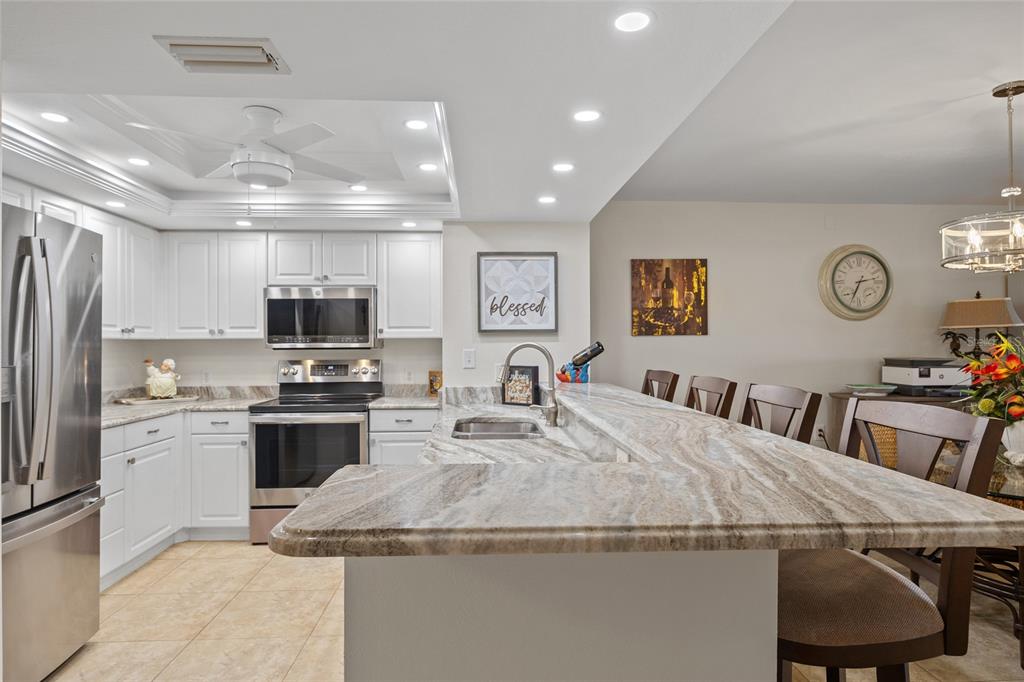 601 Shreve Street, Unit 53C Punta Gorda, FL 33950 - Photo 8 of 30 a kitchen with stainless steel appliances granite countertop a sink a stove a refrigerator cabinets and chairs