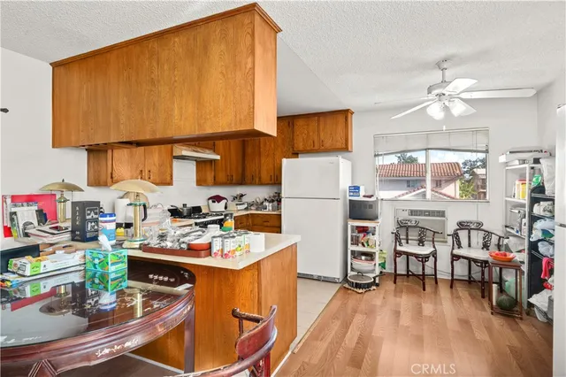 a open kitchen with stainless steel appliances granite countertop a stove refrigerator and cabinets with wooden floor