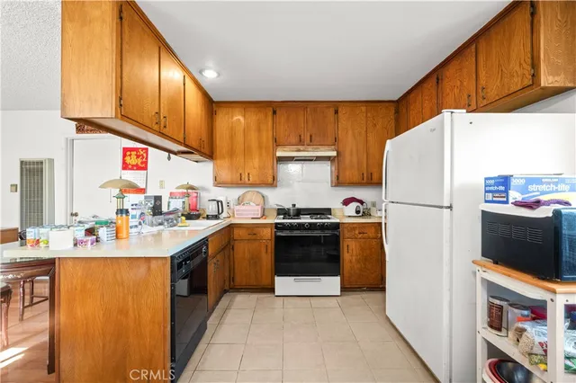 a kitchen with stainless steel appliances granite countertop a refrigerator sink stove and cabinets