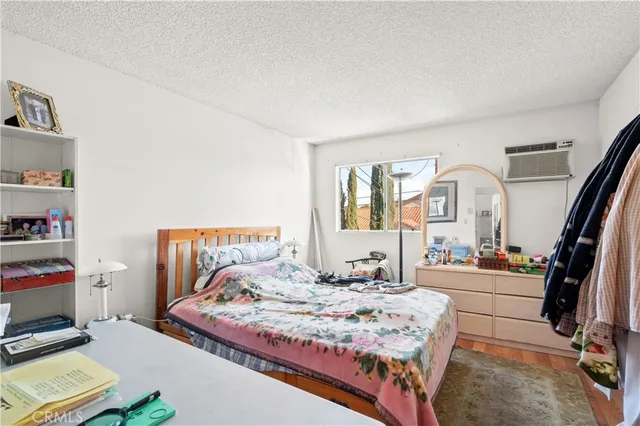 a bedroom with a bed a large window and book shelf