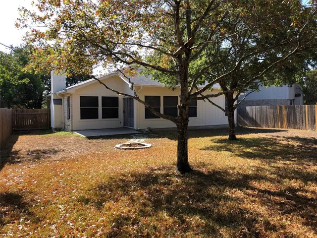 an empty room with wooden floor and a ceiling fan