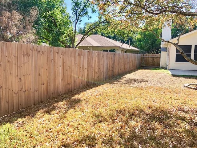 an empty room with wooden floor and a ceiling fan