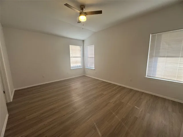 a kitchen with stainless steel appliances granite countertop a refrigerator a sink dishwasher a stove and white cabinets with wooden floor