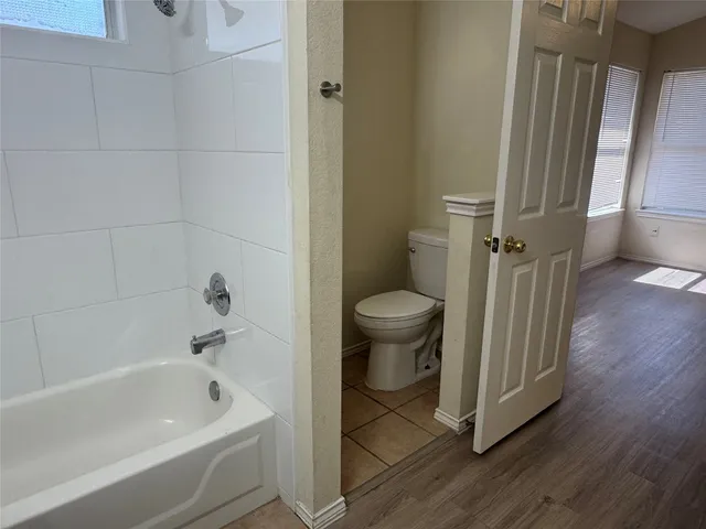 a bathroom with a tub a toilet and a sink