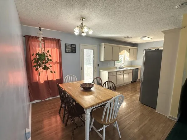 a view of a dining room with furniture a chandelier and wooden floor