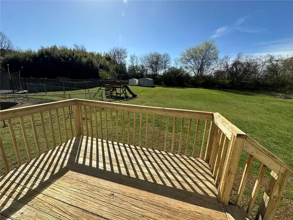 a view of a balcony with wooden floor and fence