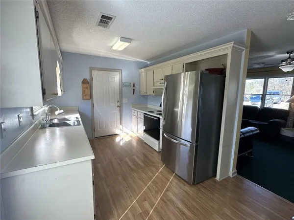 a kitchen with granite countertop a refrigerator and a sink