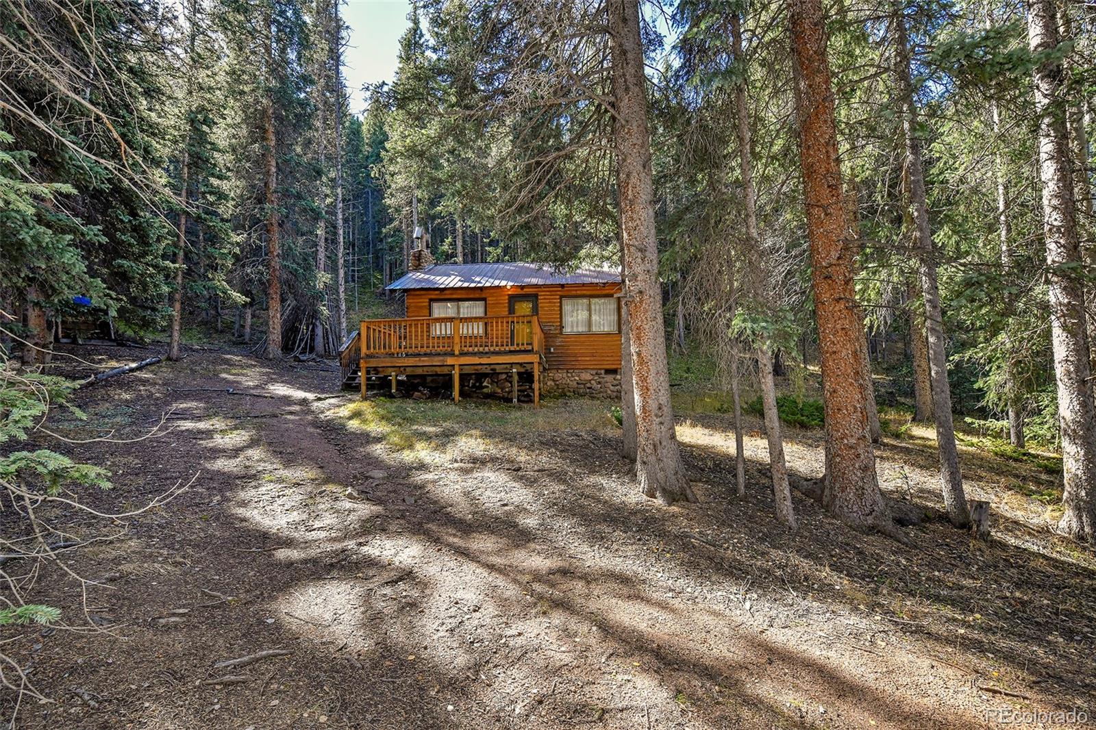 104 Usfs Divide, Unit 383 Divide, CO 80814 - Photo 27 of 41 a backyard of a house with barbeque oven table and chairs