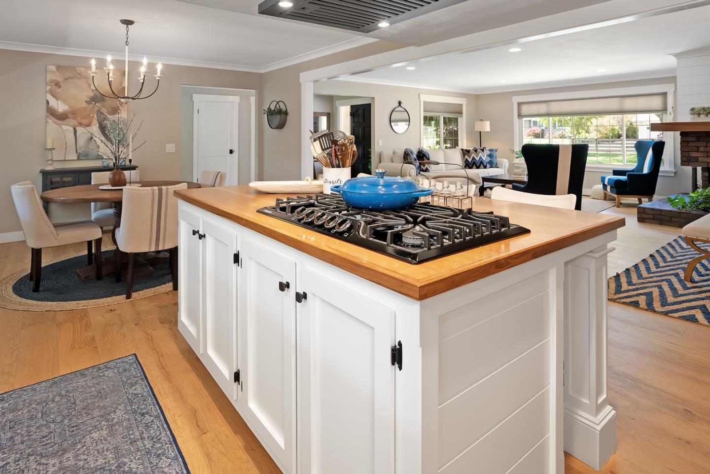 105 Rays Circle Hollister, CA 95023 - Photo 10 of 36 a kitchen with stainless steel appliances a stove a sink dishwasher a dining table and chairs with wooden floor