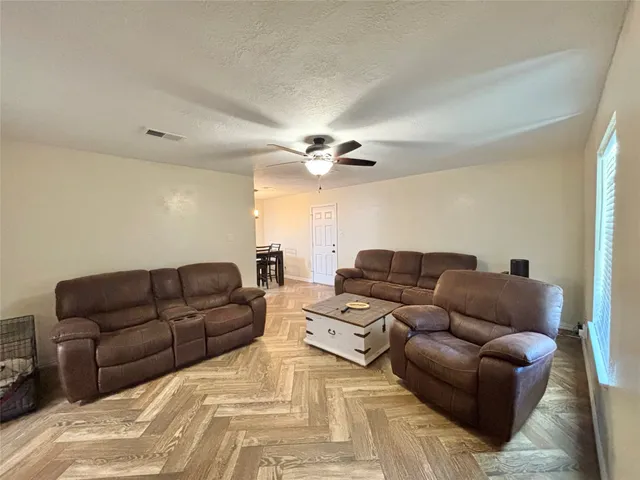 a living room with furniture ceiling fan and a rug