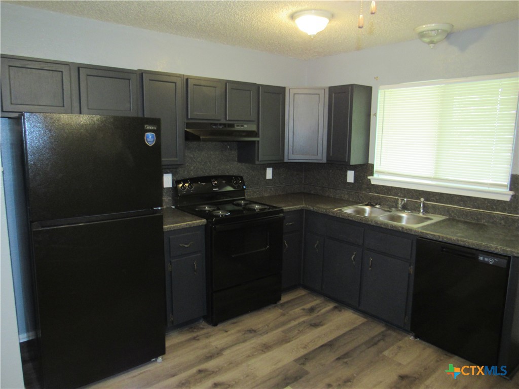 1301 Quail Circle, Unit D Killeen, TX 76549 - Photo 4 of 11 a kitchen with a refrigerator and a sink