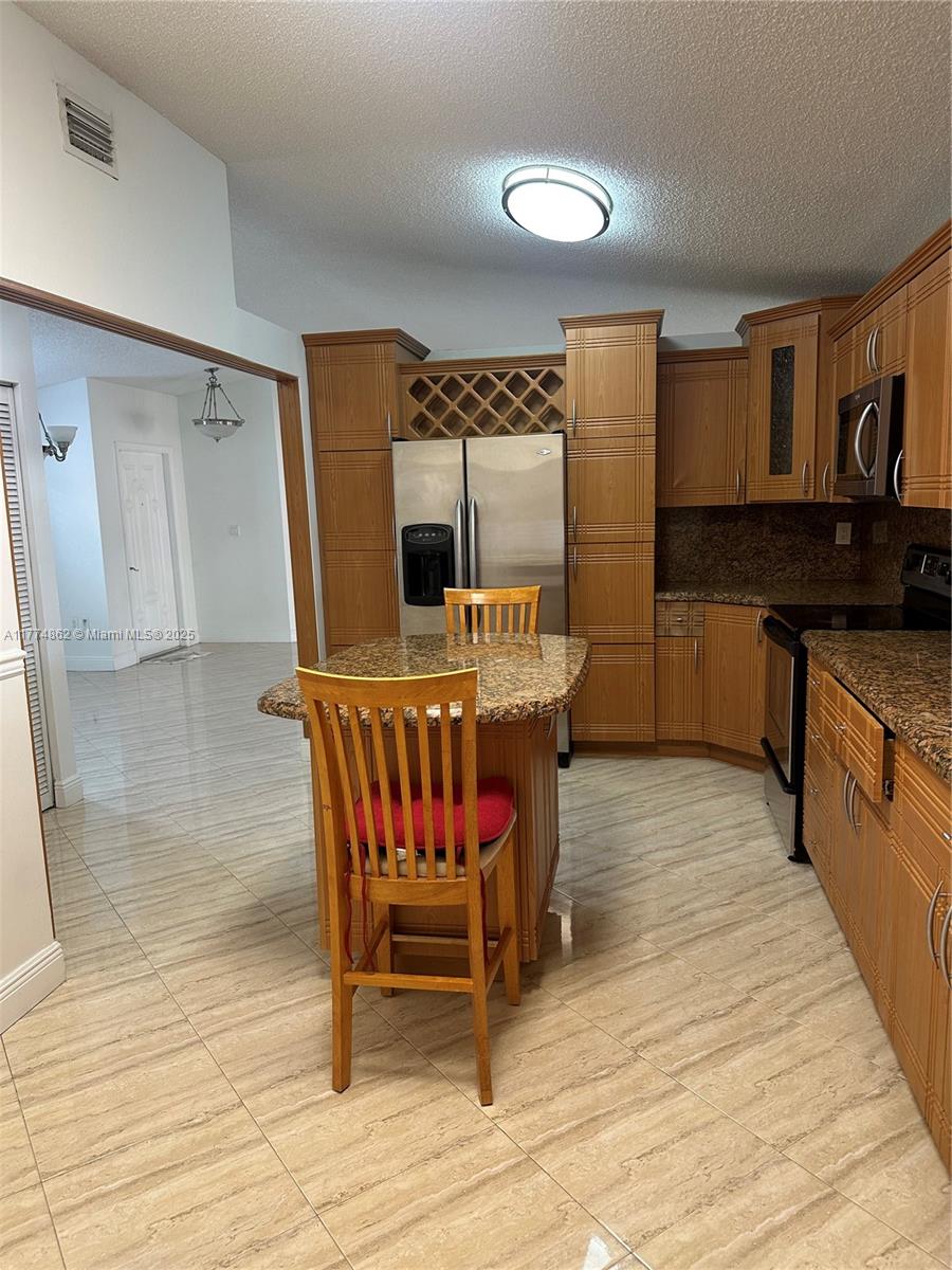 Westbrooke at Avalon Hialeah, FL 33015 - Photo 2 of 24 a kitchen with stainless steel appliances kitchen island granite countertop a sink and wooden floors