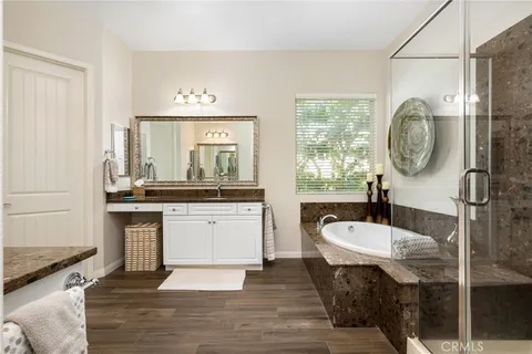 a bathroom with a double vanity sink a mirror and a bathtub
